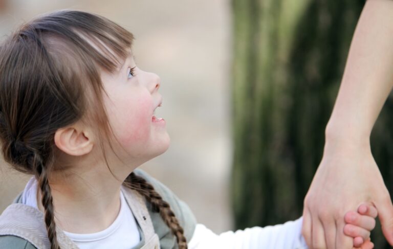 Special needs child holding mother's hand